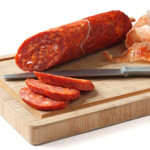Spanish chorizo sausage with knife on wooden board